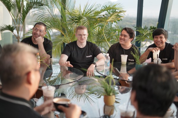 LevelUp team members sitting around a glass table, engaged in a casual conversation