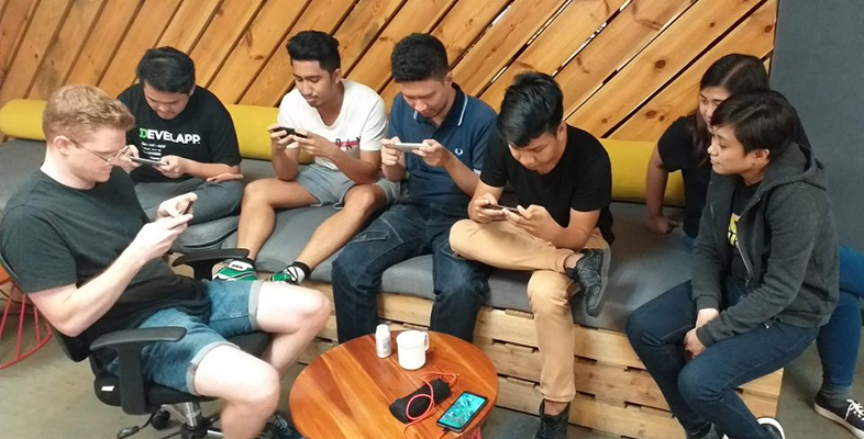 LevelUp teammates sitting together looking at their phones
