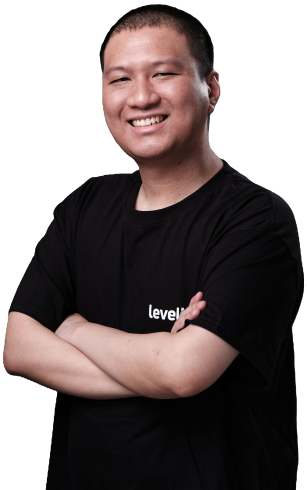 A smiling operations manager in a black LevelUp shirt, standing with arms crossed